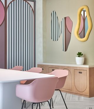 pink chair in workspace with playful mirrors on the wall