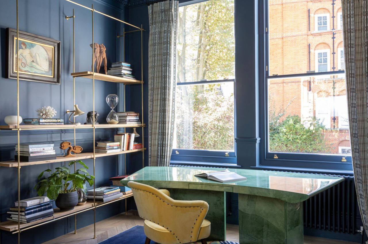 Home office with blue walls and green desk