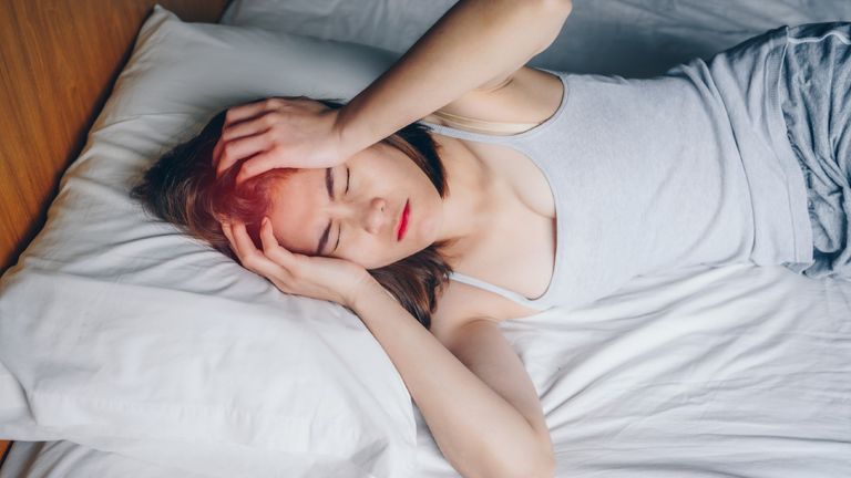 woman having headache while she lying on bed, why do I keep dreaming about my ex
