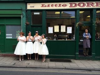 A group of women dressed in vintage clothing stand outside a shop in Borough Market in London.