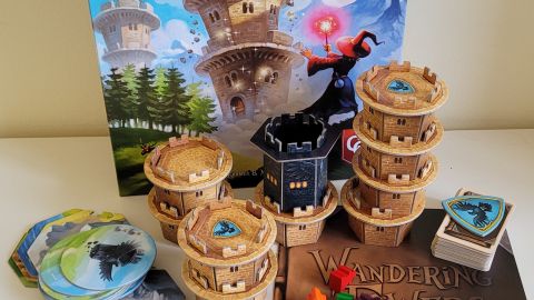 Wandering Towers box, tokens, rules, and components on a white surface