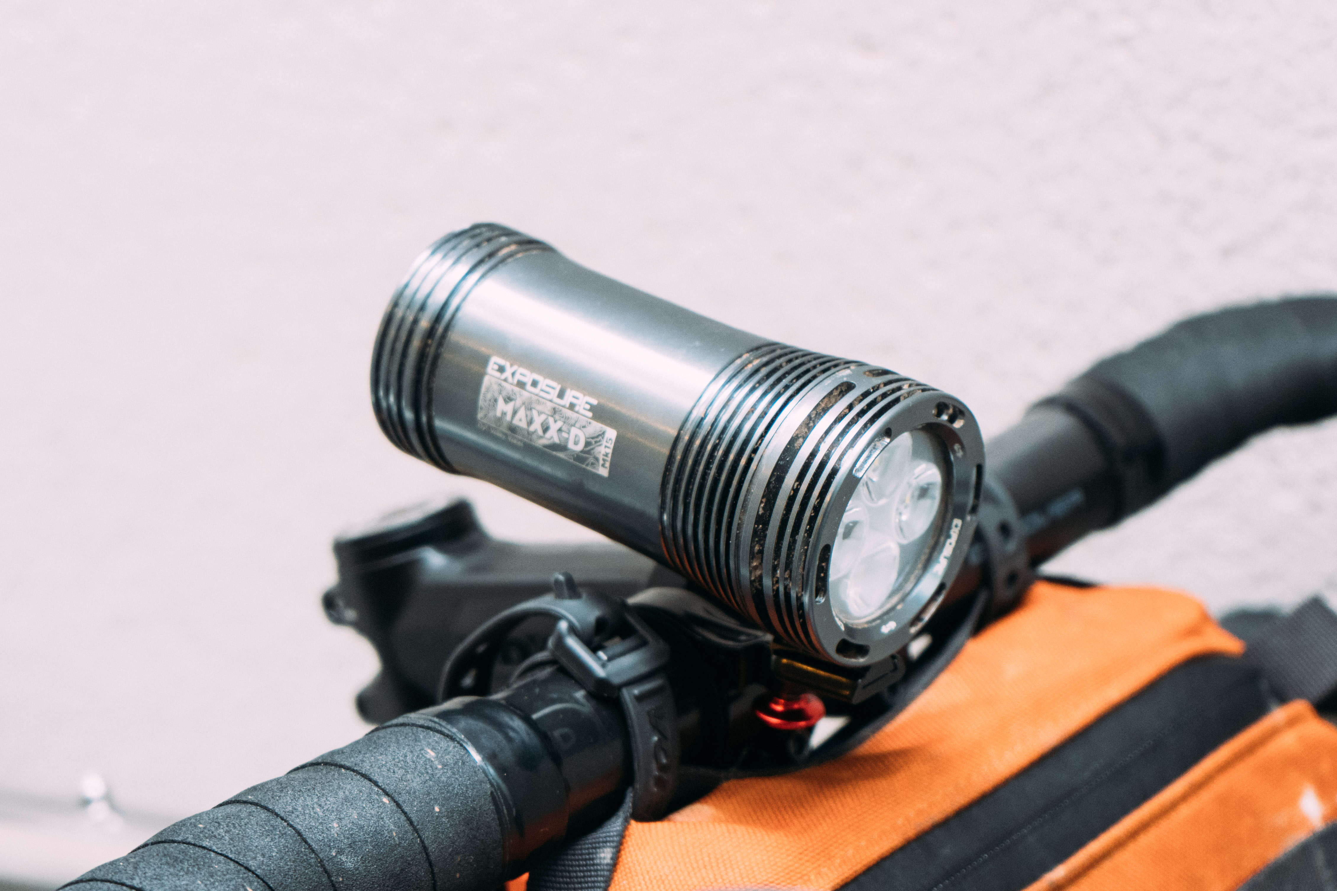 A large silver bike light mounted to the handlebars of a gravel bike