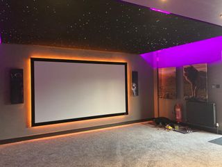 A theater and screen illuminated in orange LED with Snap One technologies.