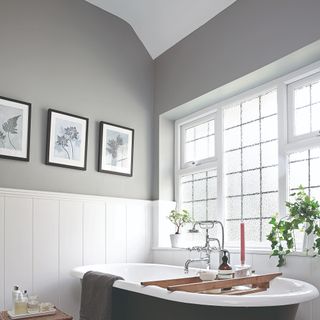 A grey-painted bathroom with a free-standing bathtub