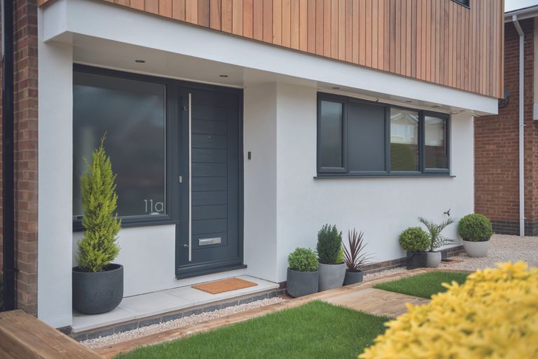 contemporary front door with dark finish against white walls by solidor