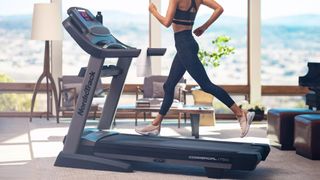 person running on NordicTrack Commercial 1750 treadmill in a room lit by large bay windows