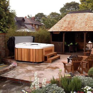 outddoor white hot tub with garden area