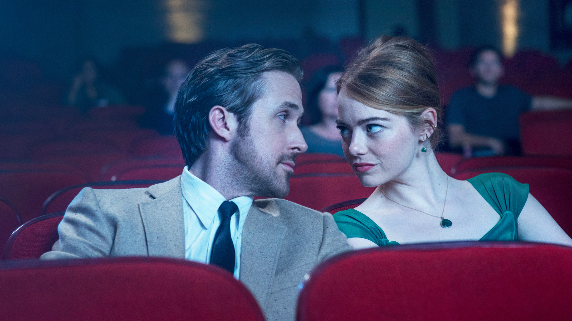 La La Land still. Mia and Sebastian gaze at each other in a cinema.