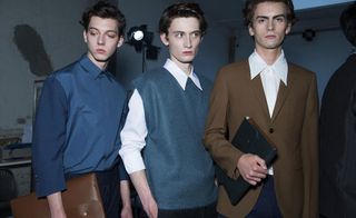 3 male models in a studio wearing brown & blue clothing