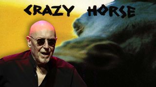 Pete Agnew looking angry in front of the cover artwork of Crazy Horse's debut album