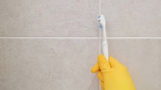 cleaning grout with toothbrush