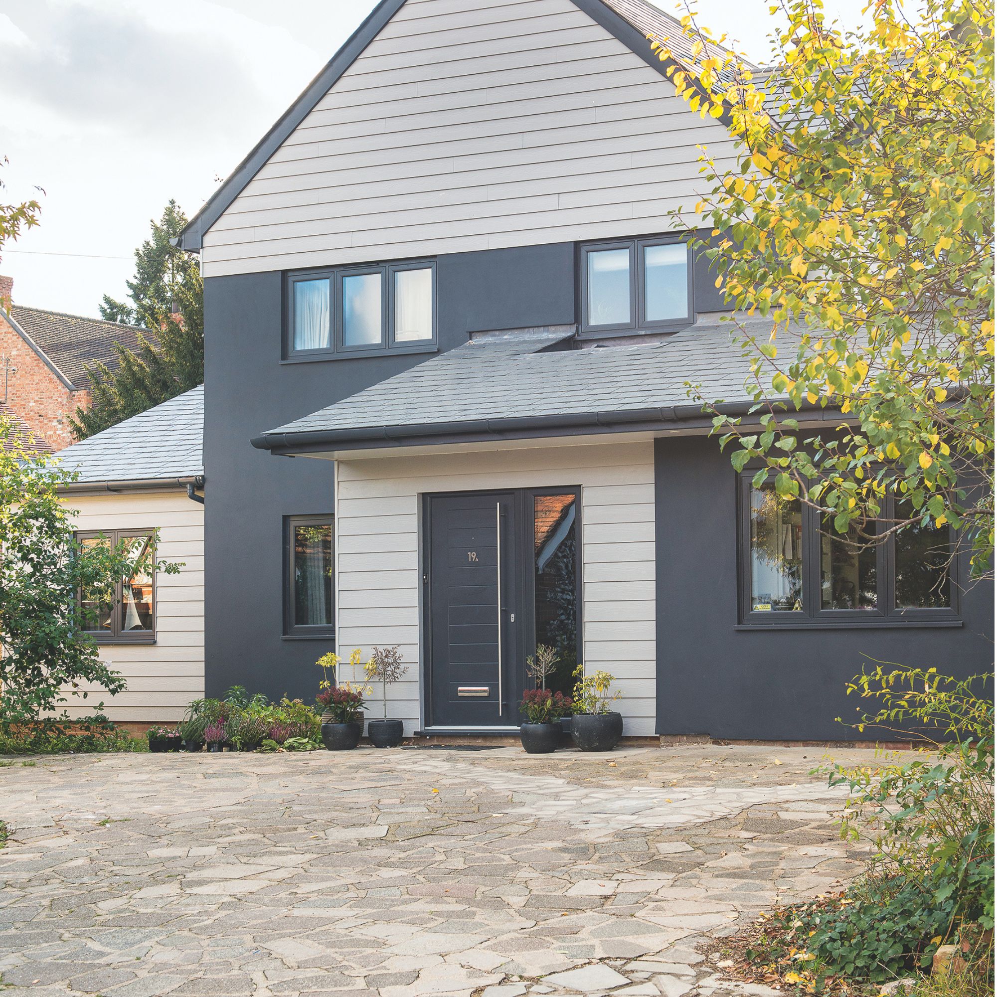 Driveway of contemporary clad and render house