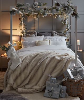 A four-poster bed in bedroom with floral decor and layered bedding