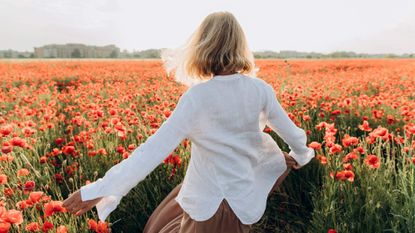 Woman dancing in poppy field