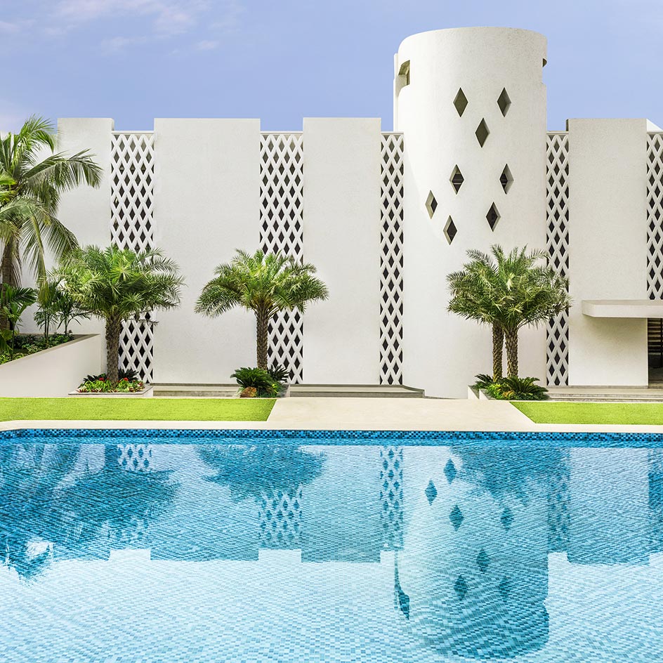 Outside swimming pool with palm trees behind