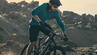 Man mountain biking wearing Garmin Fenix 7 watch