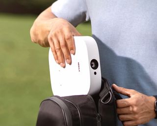 Nebula Solar portable projector being packed into a backpack by man in light colored tshirt