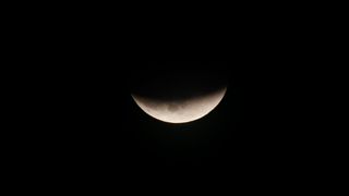 Earth's dark umbral shadow covers the moon.