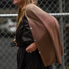 A guest is seen wearing a brown cardigan, brown top, brown skirt and a black bag outside the Tibi show during NYFW S/S 2024 on September 09, 2023 in New York City.