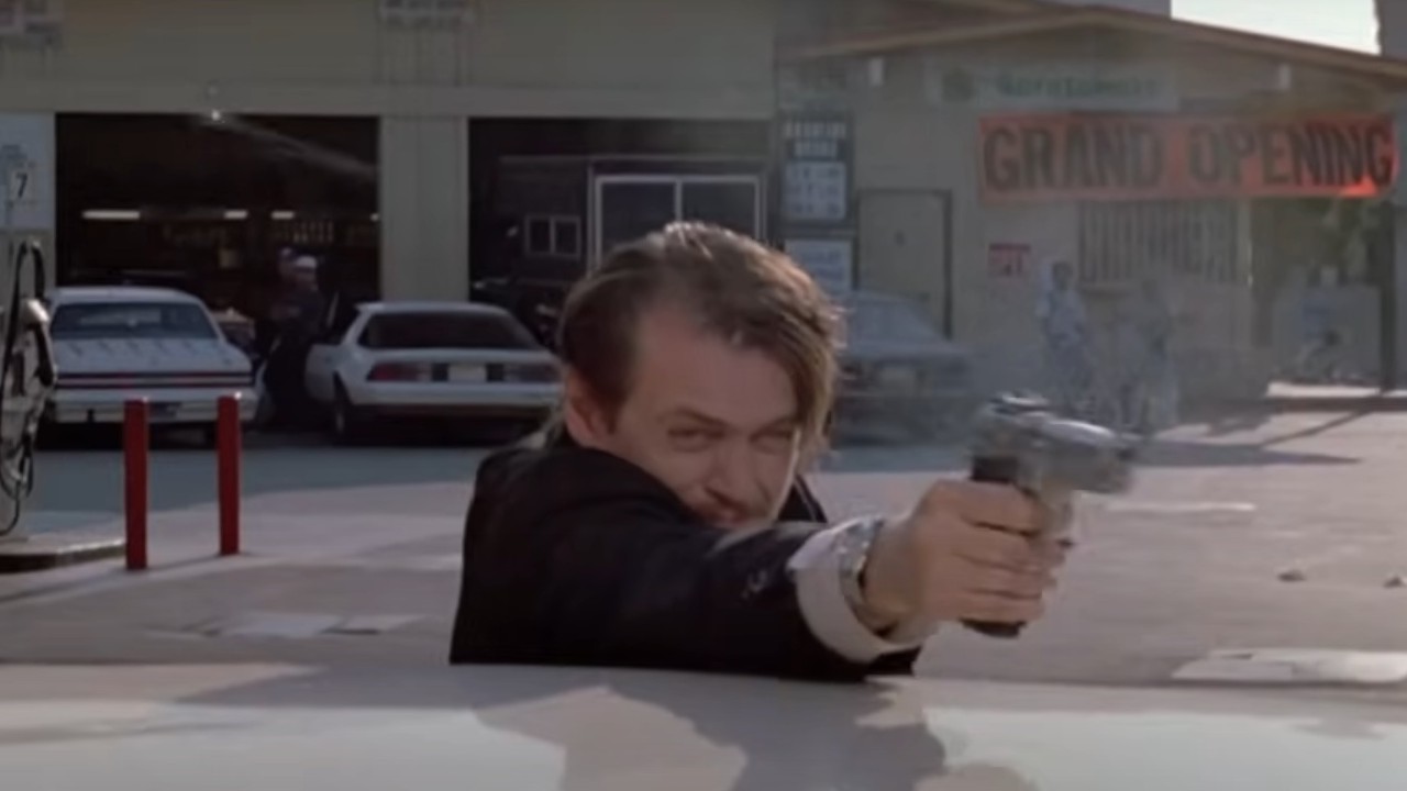 Steve Buscemi firing a gun over a car roof in Reservoir Dogs