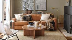 Living room with brown leather sofa and round wooden coffee table