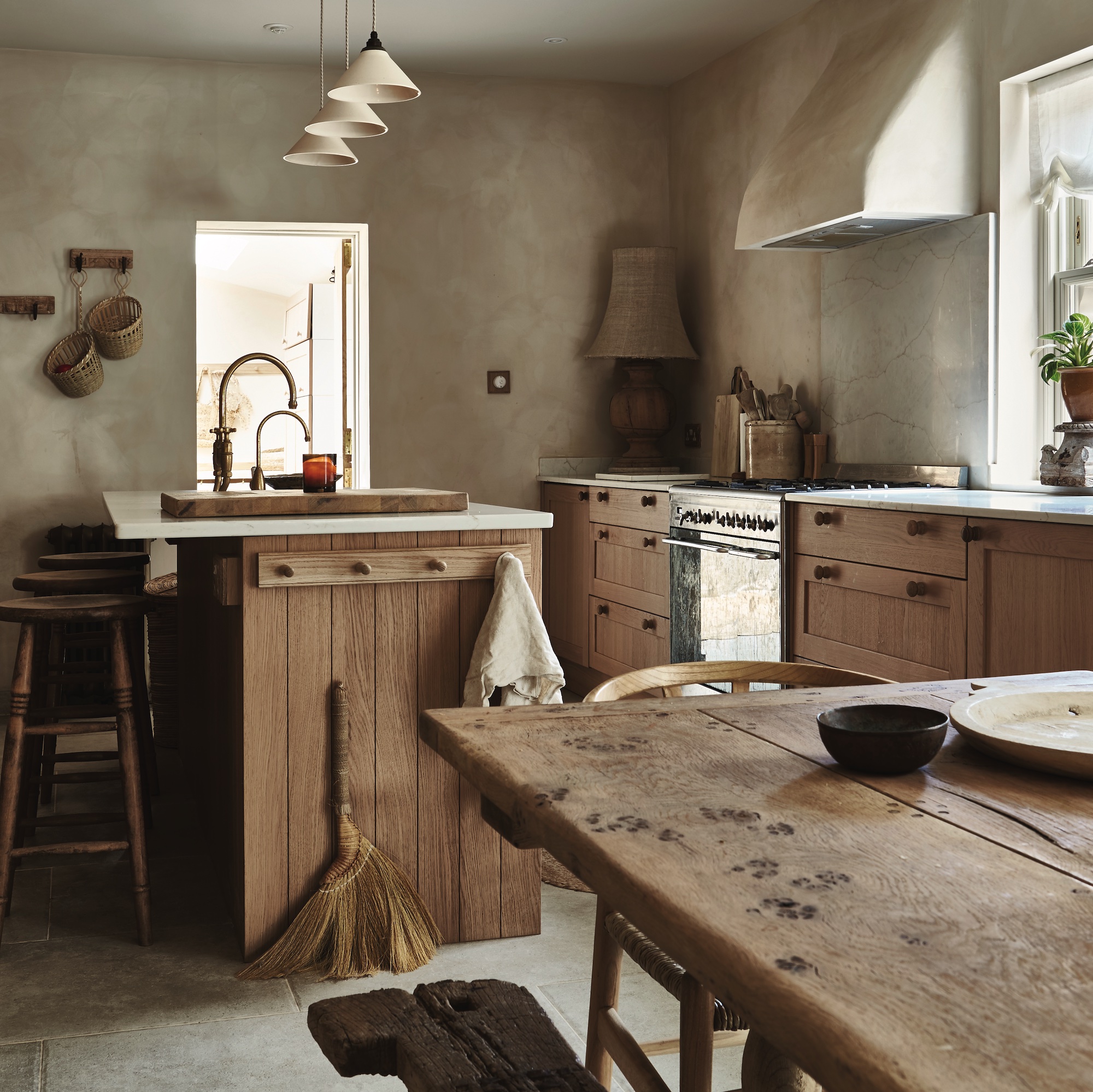 kitchen with limewash walls, wooden island and floor cabinets, and farmhouse table