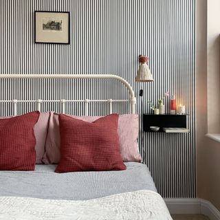 Guest bedroom with stripy wallpaper and floating bedside cabinets