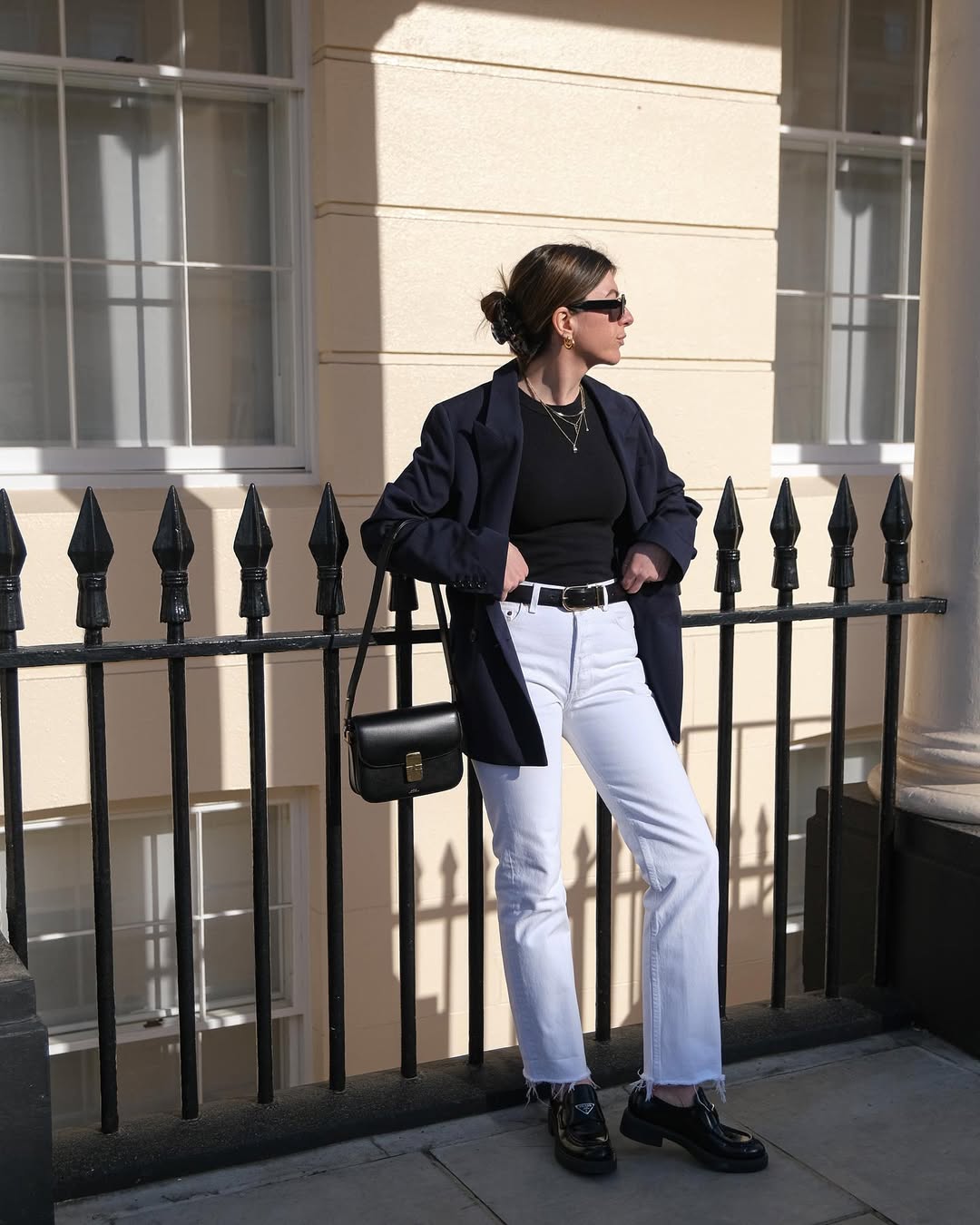 A woman wears a tailored blazer, black tshirt and jeans