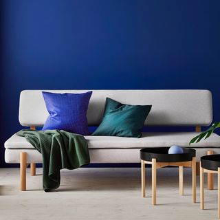 white sofa with cushion and blue wall