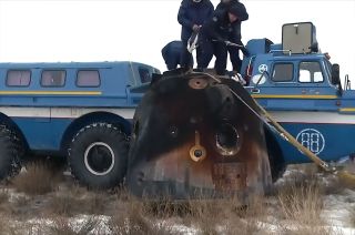 Russia's Soyuz MS-20 descent module is seen beside a recovery vehicle after landing upright in Kazakhstan from the International Space Station with cosmonaut Alexander Misurkin of Roscosmos and Japanese spaceflight participants Yusaku Maezawa and Yozo Hirano on Sunday, Dec. 19, 2021.