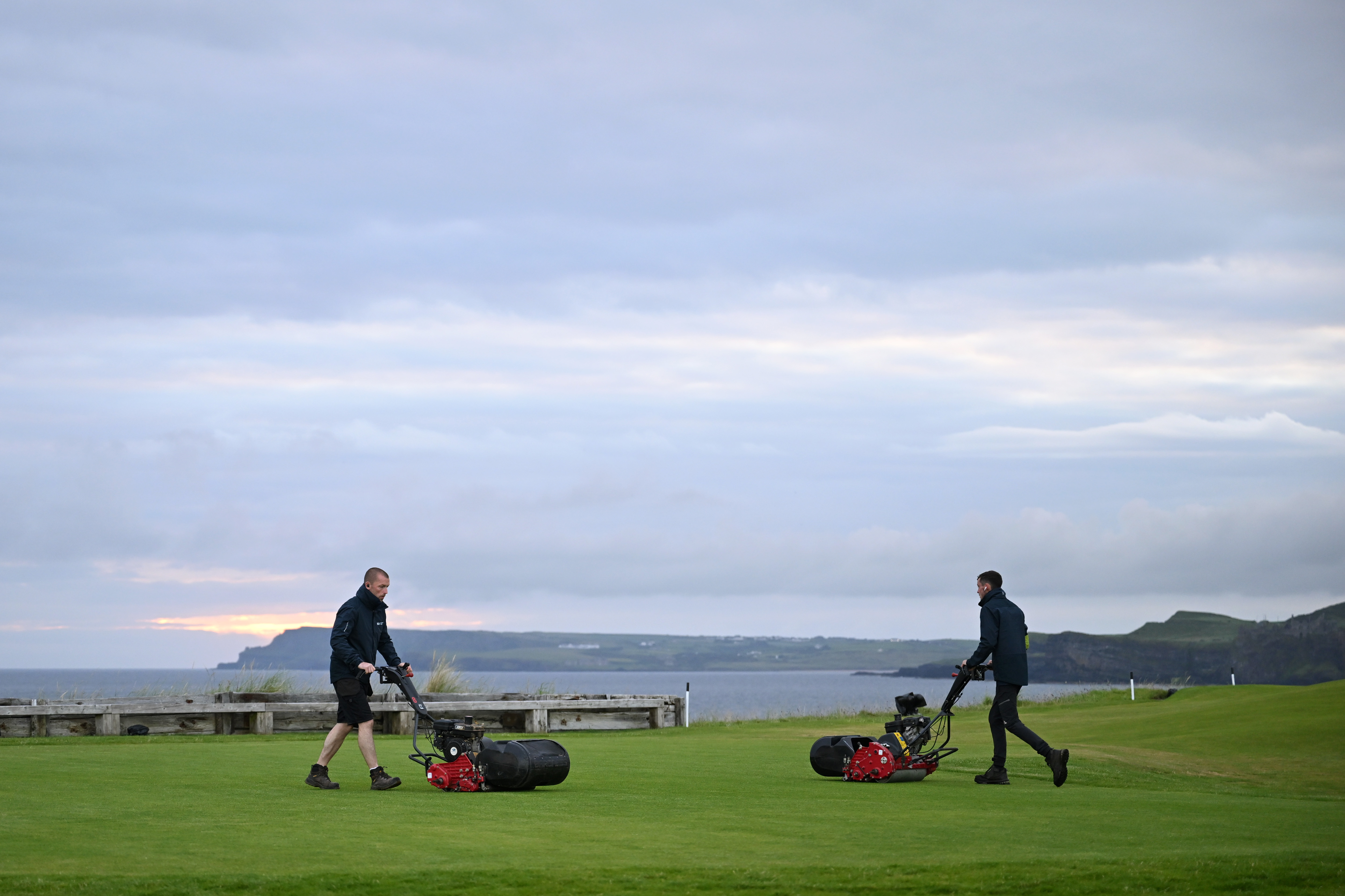 Greenkeepers cut grass