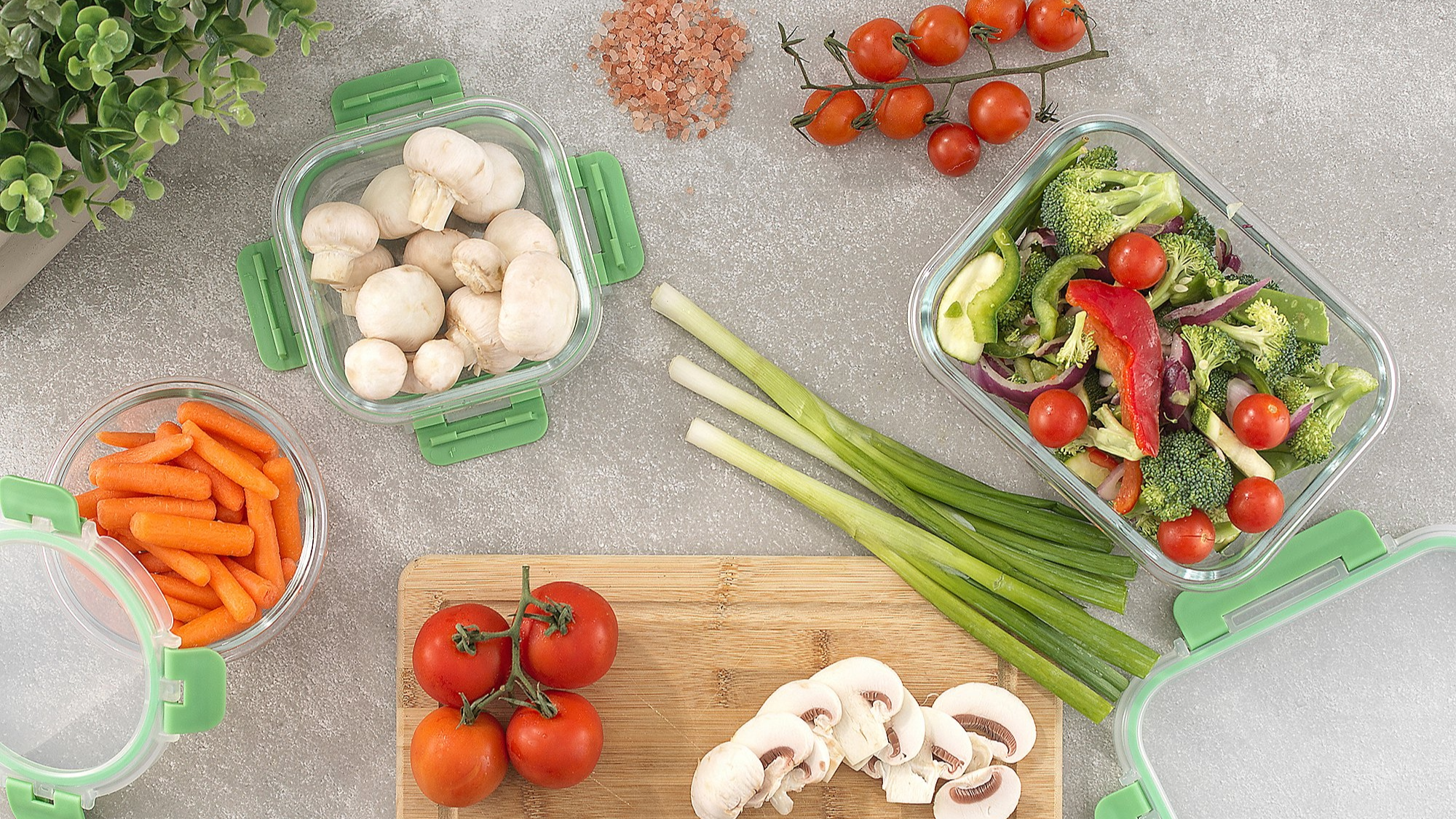 A salad being prepared for a picnic in food storage boxes.