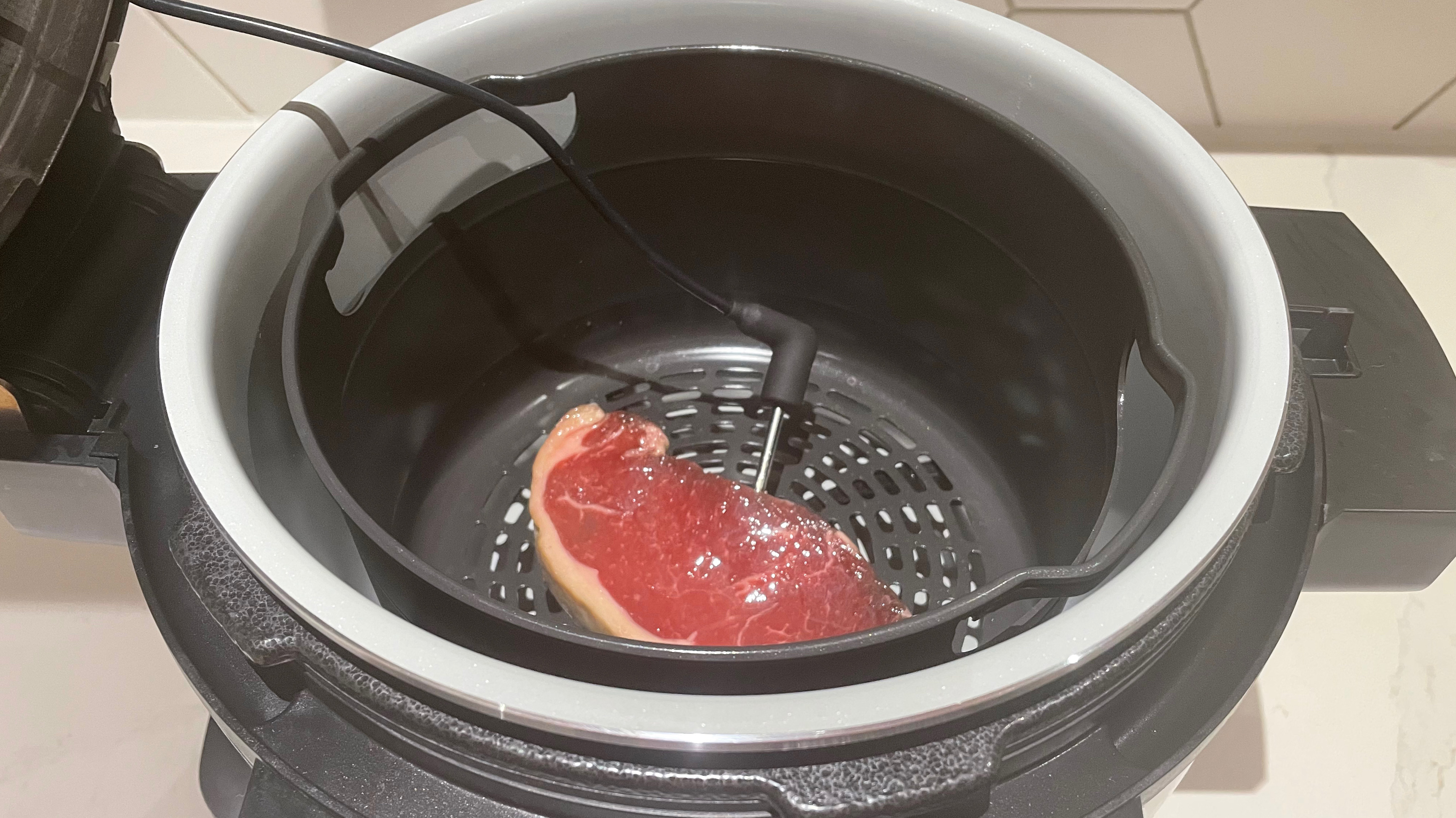 Steak being cooked in the Ninja Foodi 15-in-1 SmartLid Multi-Cooker