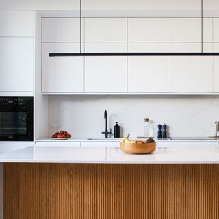 kitchen island in front of glossy white kitchen cabinets