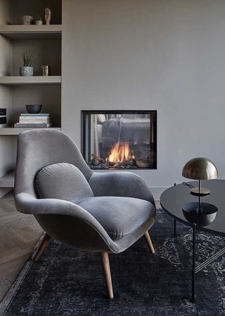 Mauritzhof Hotel room with grey chair, black table and fireplace in the wall