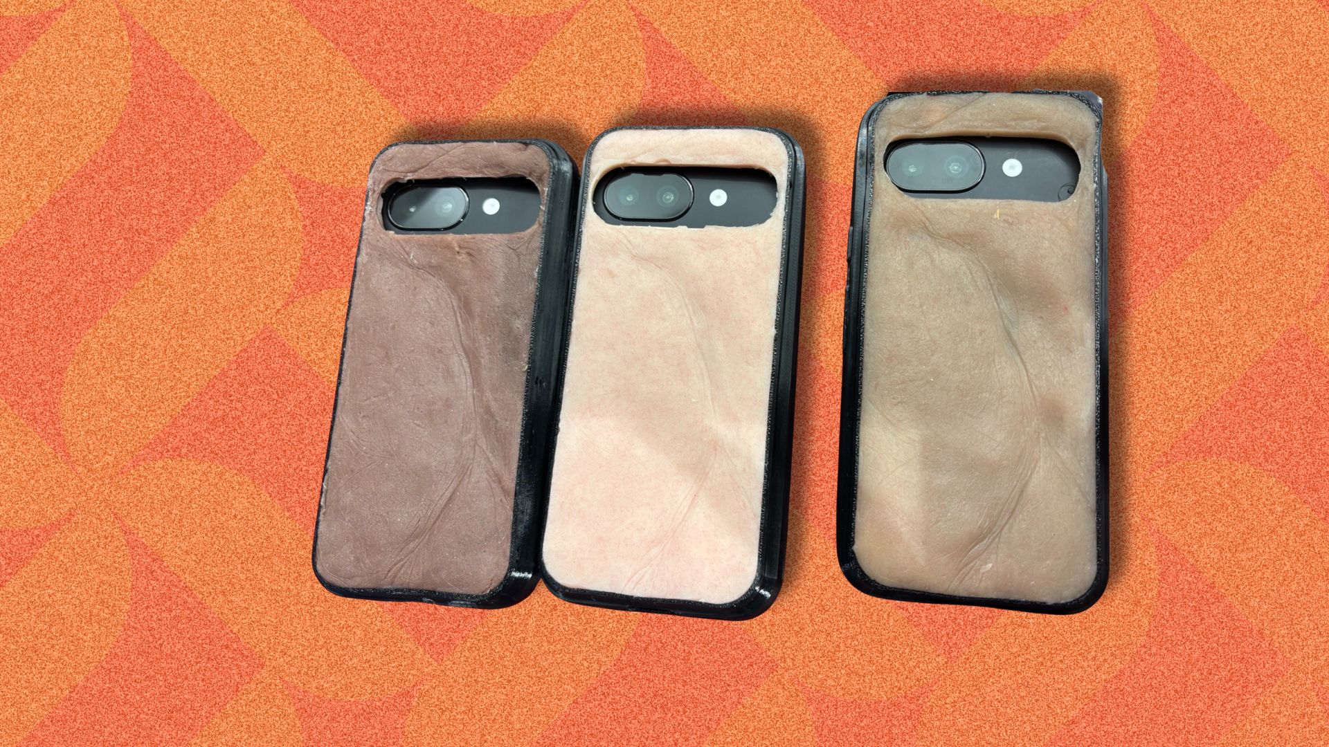an image of three of the skincase phone cases all with different skintones. They are against an orange patterned background