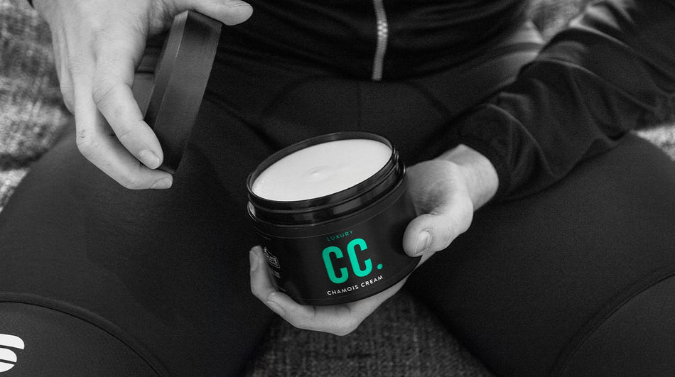 Muc-Off Luxury Chamois Cream being held in the hand of a rider as they unscrew the lid