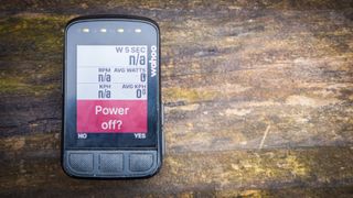 Wahoo Elemnt Bolt sits on a wooden bench with the 'power off' warning screen