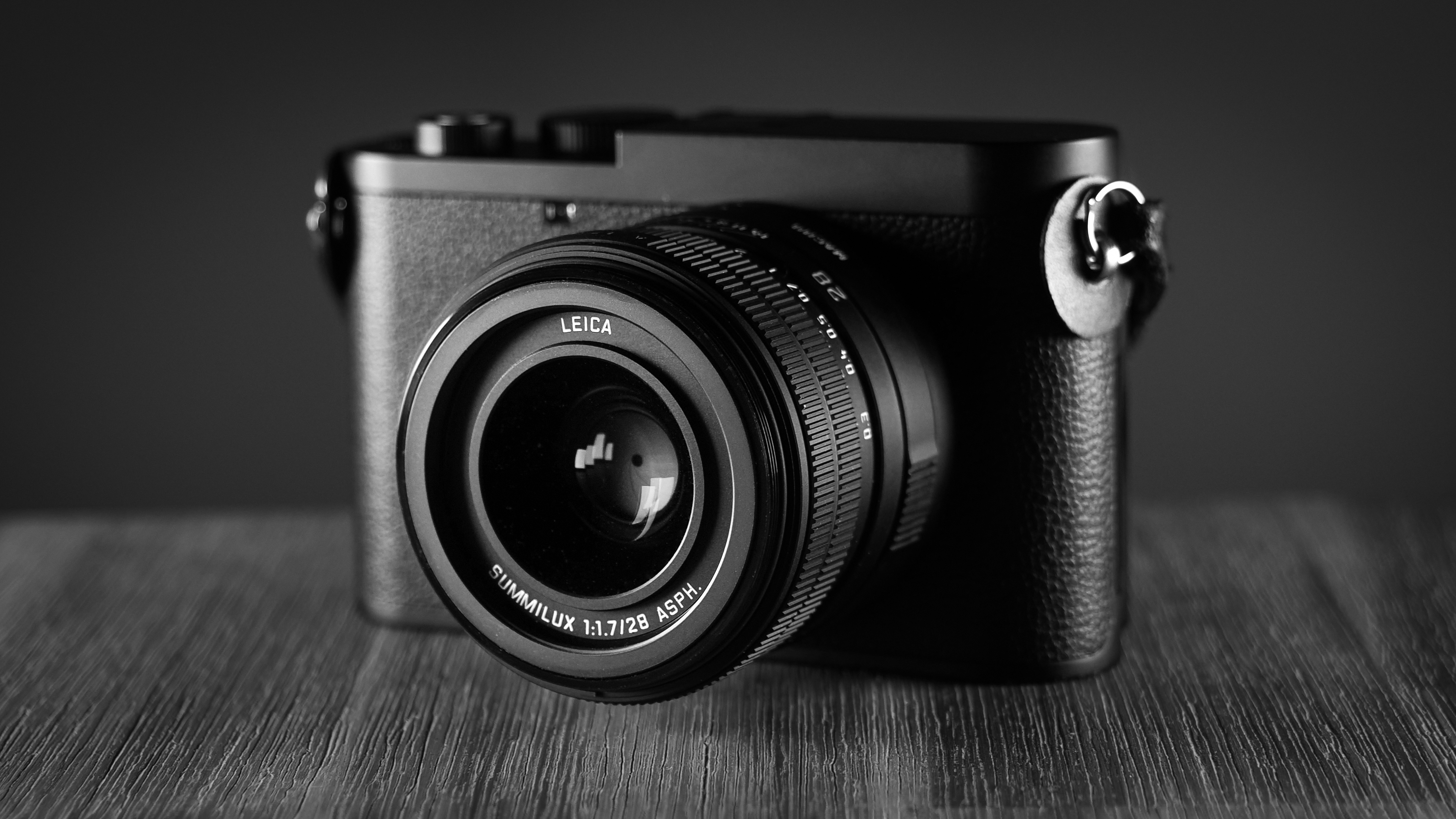 Black-and-white image of the Leica Q3 Monochrom on a wooden surface