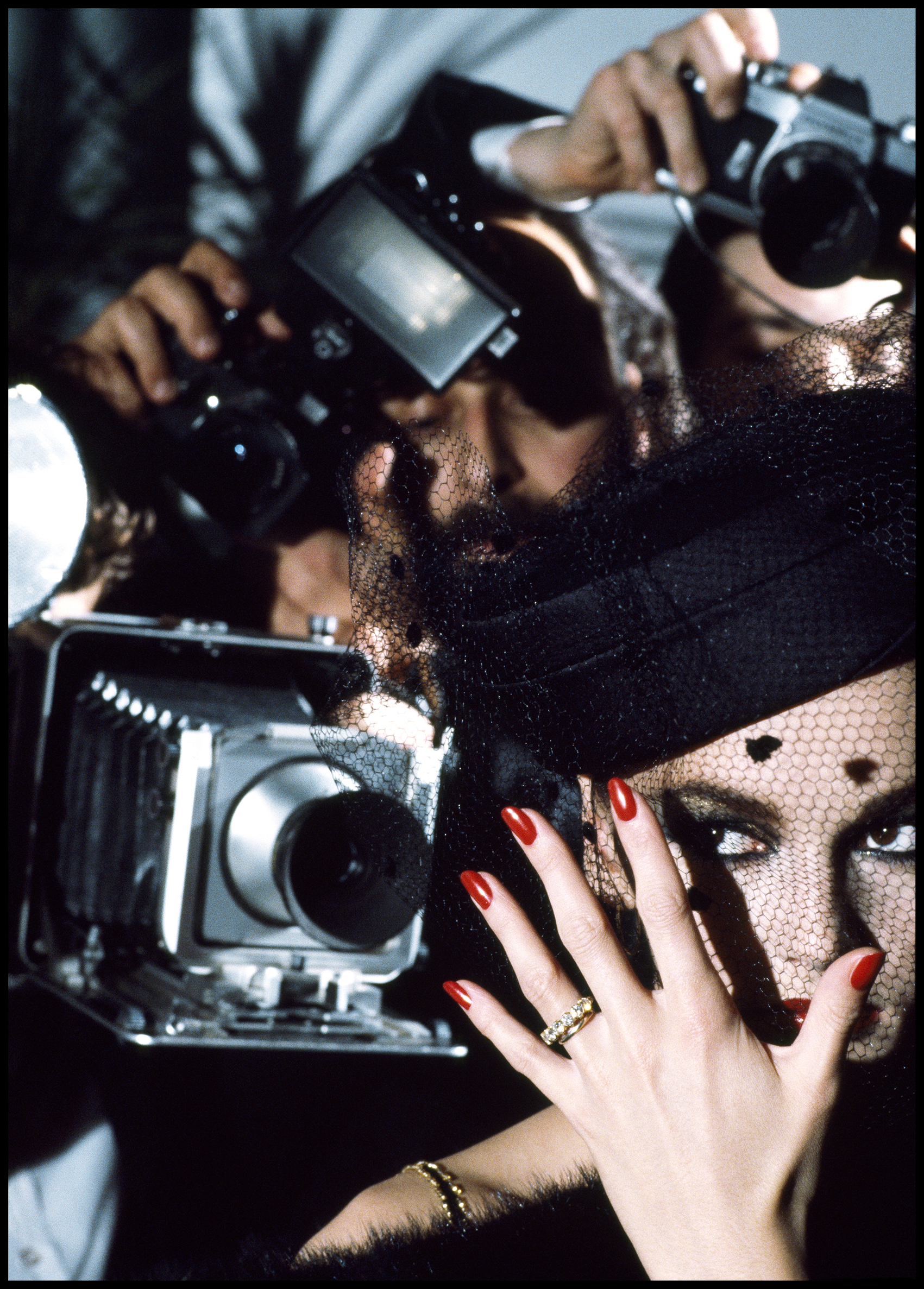 A woman displaying her hands adorned with bright red nail polish