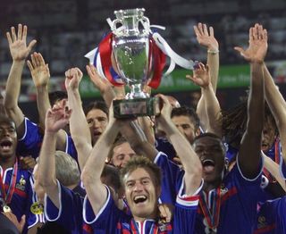 Didier Deschamps lifts the European Championship trophy as France players celebrate victory over Italy in the final of Euro 2000.