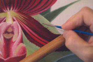 Painting details on an orchid with oil paints 