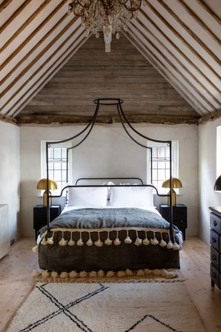 large neutral bedroom with a modern four poster bed