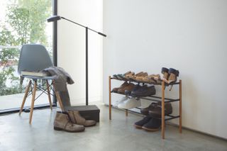 shoe storage rack in a hallway with chair and floor lamp