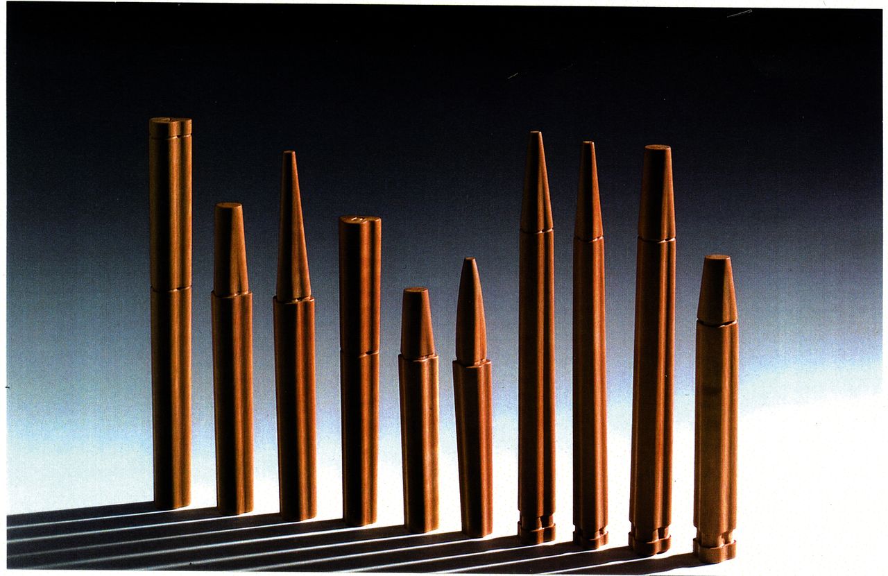 The original wooden prototypes of the pens designed by Achille Castiglioni and Gianfranco Cavaglià and made by Bottega Ghianda, found hidden behind a mirror in Castiglioni’s Milan studio. Different shaped wooden pens in a row with long shadows in front of them.