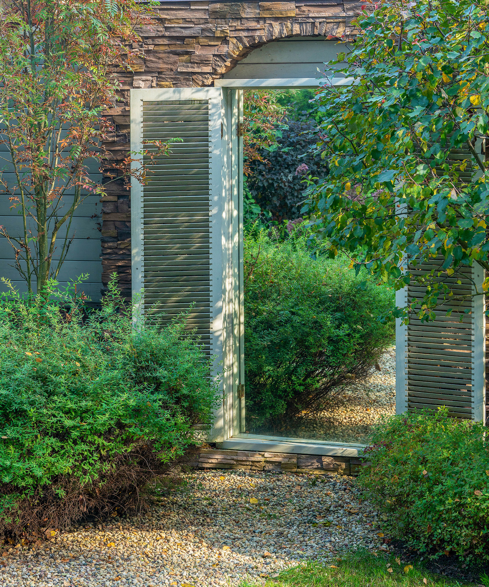 mirror in garden wall framed by doors