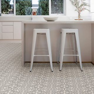 Gray patterned peel and stick flooring fitted in a kitchen around an island. 