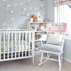 Children's nursery with cot, rocking chair and stuffed animals in a bookcase