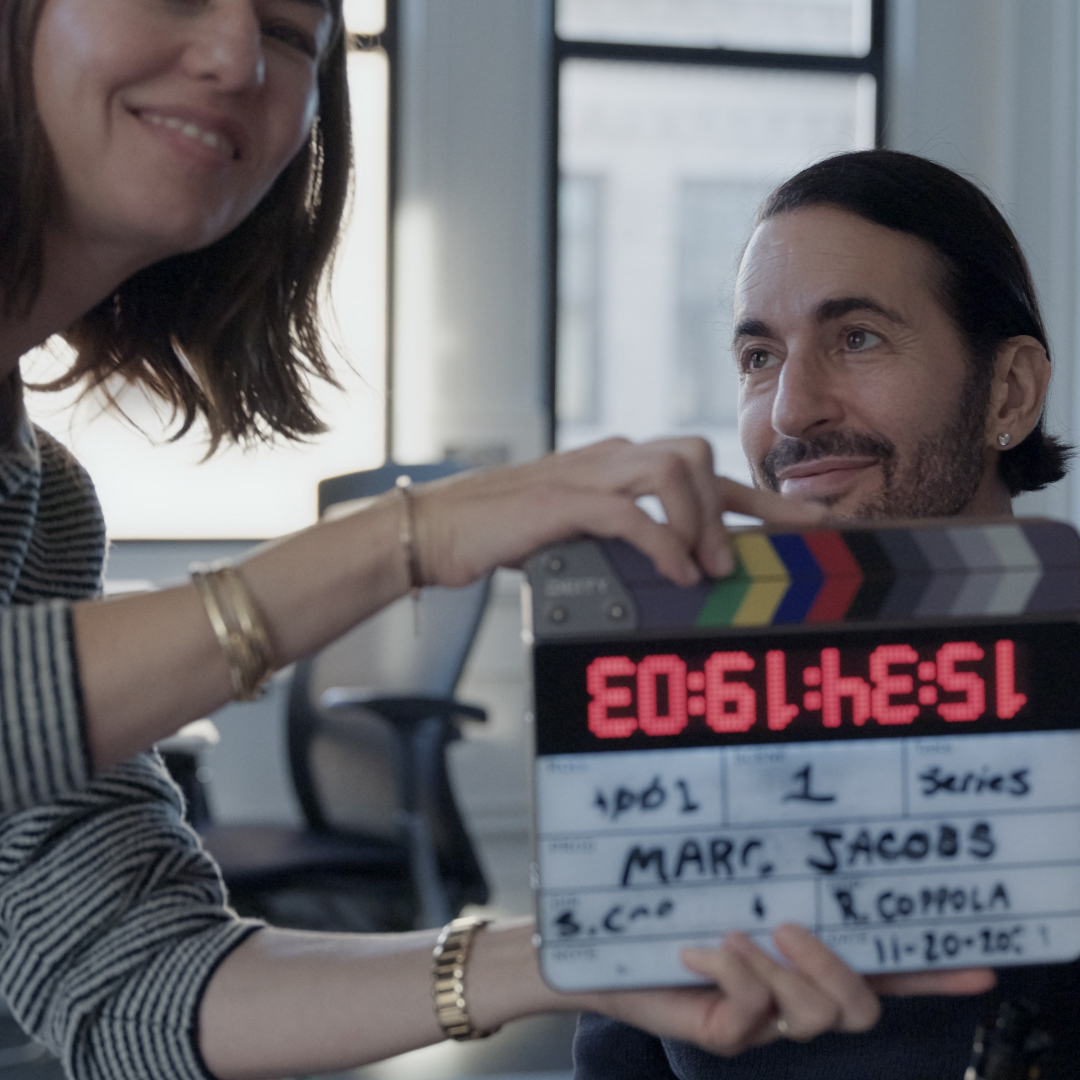 sofia coppola holds a clapper board in front of marc jacobs as he gets ready for an interview in the documentary marc by sofia