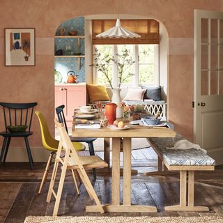dining room with peach wall archway and wooden flooring